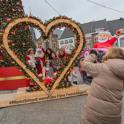 Mensen in groot hart met kerstmand en kerstboom