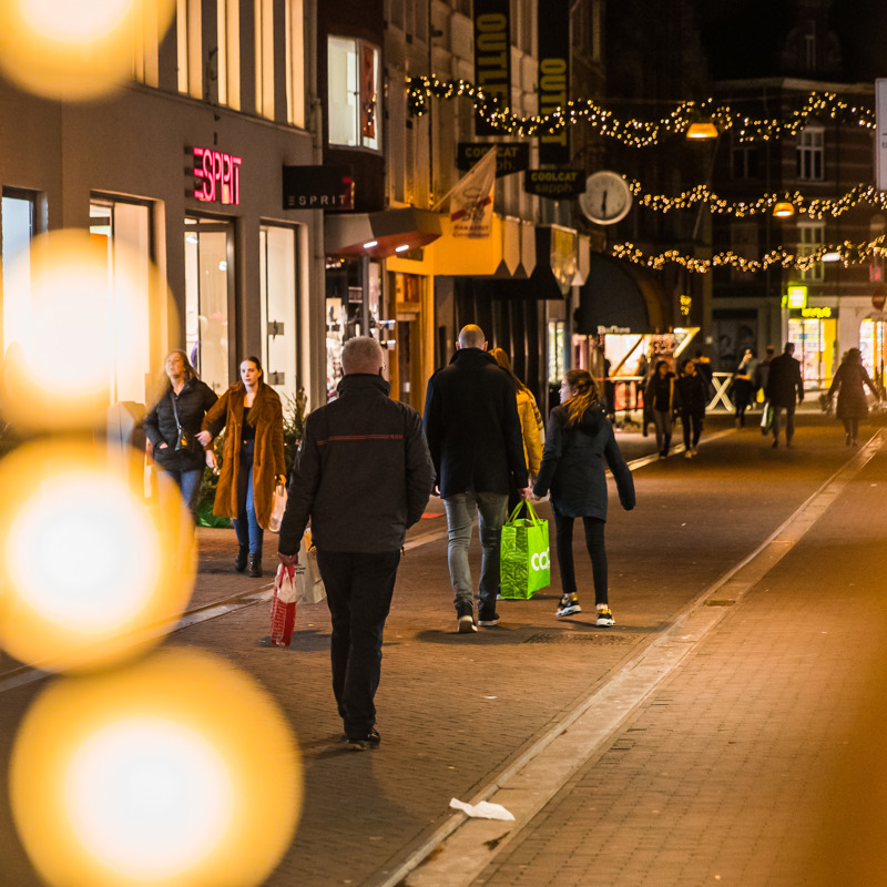 Winkelende mensen in een kerstversierde winkelstraat in Sittard