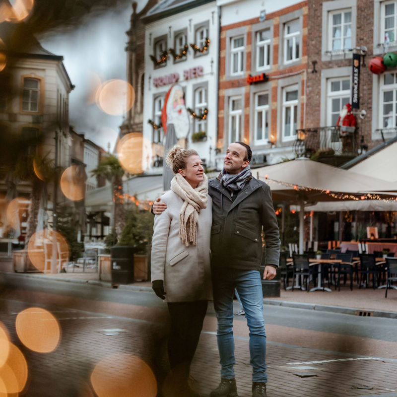 Koppel staan arm in arm op met Kerst versierde Markt in Sittard